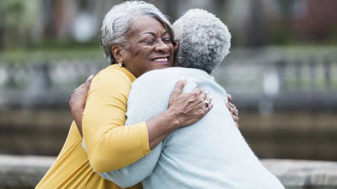 Two lifelong friends hugging.