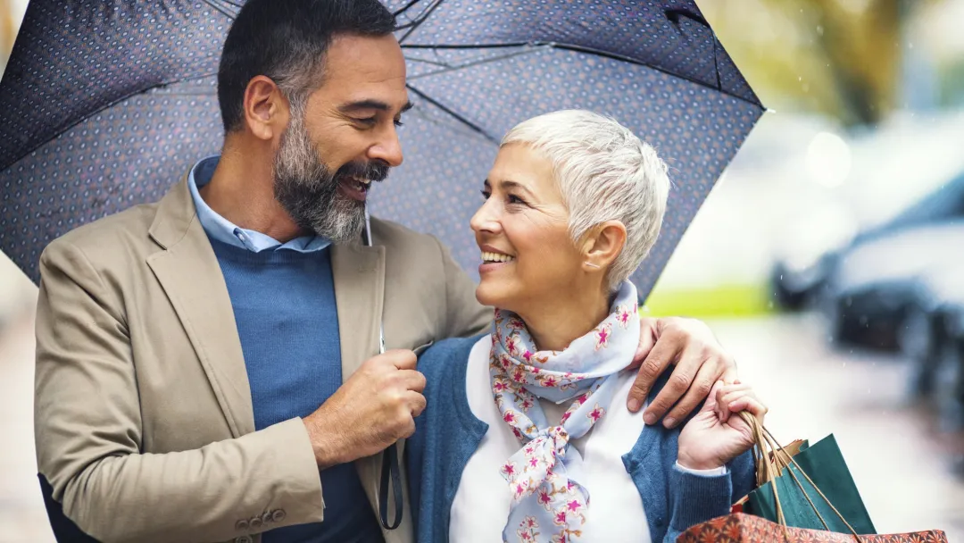 A couple takes a walk under an umbrella.