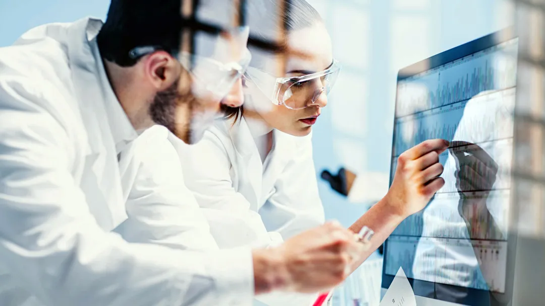 Two Physicians Look Over Test Results While in Scrubs