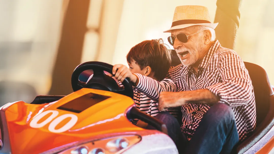 Grandfather and grandson playing in a bumper car