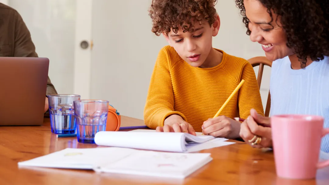 Mon and Son doing schoolwork at table