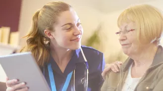 A nurse talking to a patient at an office.