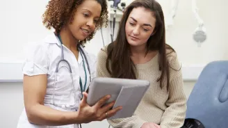 A young woman consults with her physician.