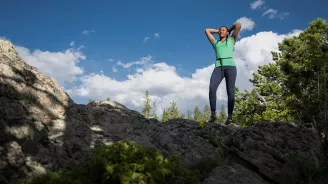 Woman on top of cliff.