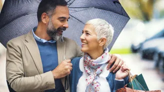 A couple takes a walk under an umbrella.