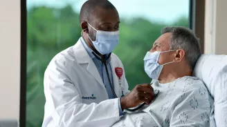 Masked doctor with masked patient in Emergency Room