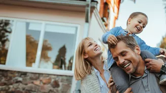 Smiling Parents with Son on Father's shoulders outdoors