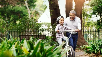 Father teach son how to ride a bike.