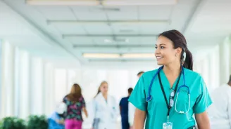Female health care professional walking down hospital hallway