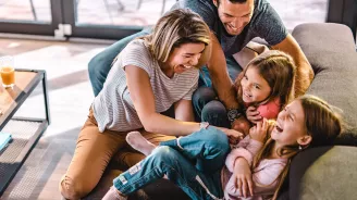 Happy family playing together on the couch.