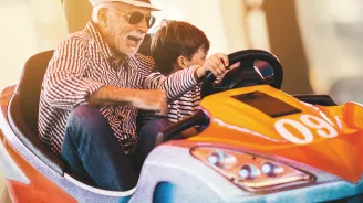 Grandfather and grandson playing in a bumper car