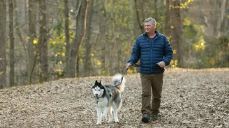 Mark and his dog walking in the woods