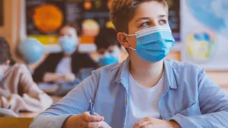 Male student wearing mask in classroom