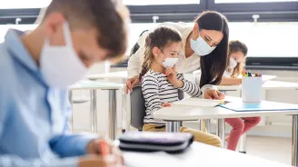 Teacher in classroom with students wearing masks