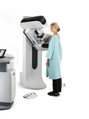 A woman getting a mammogram done with a 3D mammography machine