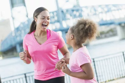 Mother and daughter holding hands for pink run