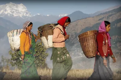 International women walking with baskets on their backs.