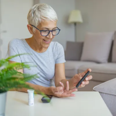 Older caucasion woman checking blood glucose