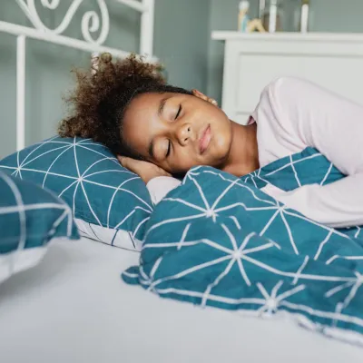 A Young Girl Sleeps Soundly in Her Bed