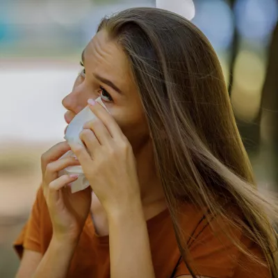 A Women Cleaning Her Eye with a Tissue.