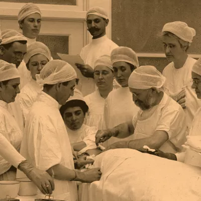 Doctor performing surgery while students watch