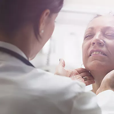 An older female patients receives care from a doctor.