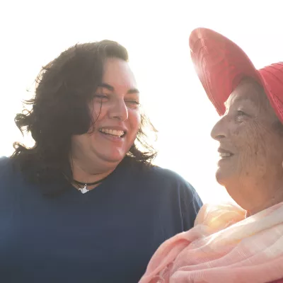 Two overweight women converse with each other.