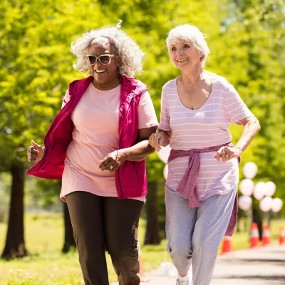 Two elderly women walking in the park.