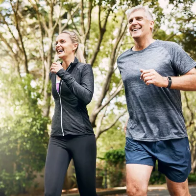 A couple runs outside together.