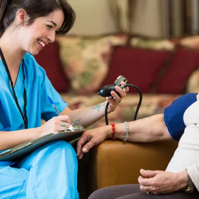 Woman having blood pressure screened
