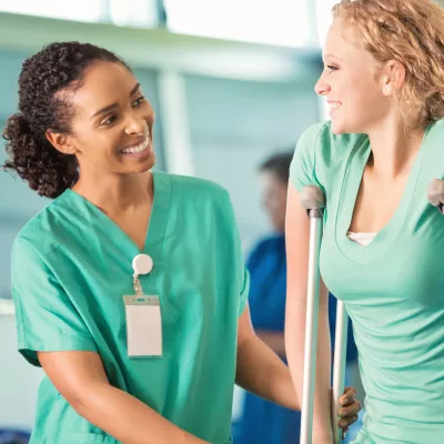 A woman talks with her physical therapist about her next steps once she's off crutches.