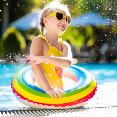 A little girl enjoys a refreshing dip in the pool.