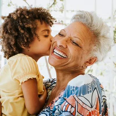 Grandmother getting a kiss from her granddaughter.