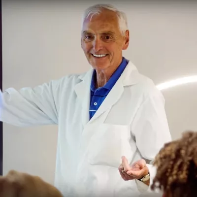 Older male Adventist professor teaching a class.