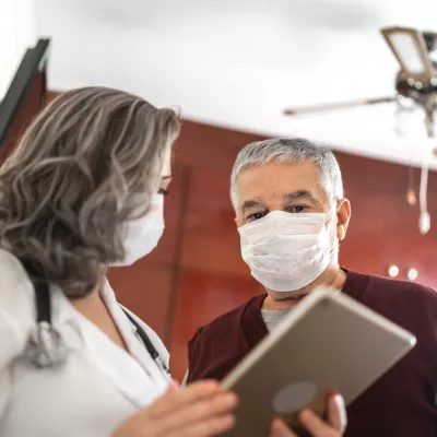 Mature female doctor talking to a male patient