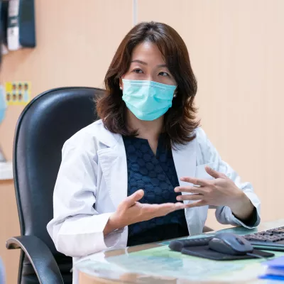 A doctor and patient during an office visit wearing masks.