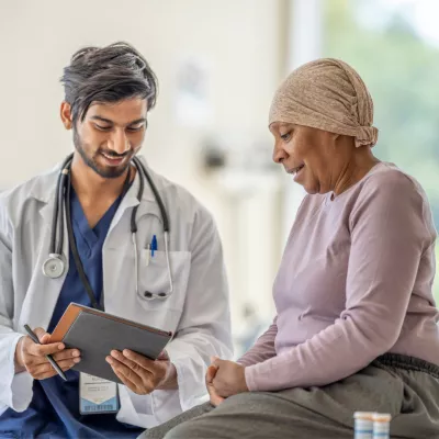 Doctor explaining to an older woman cancer patient her test results.