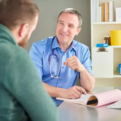 Doctor casually talking with patient while taking notes