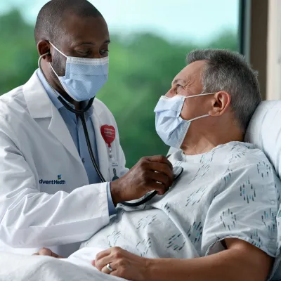 Masked doctor with masked patient in Emergency Room