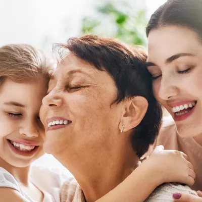 A girl, a young woman, and an older woman hugging.