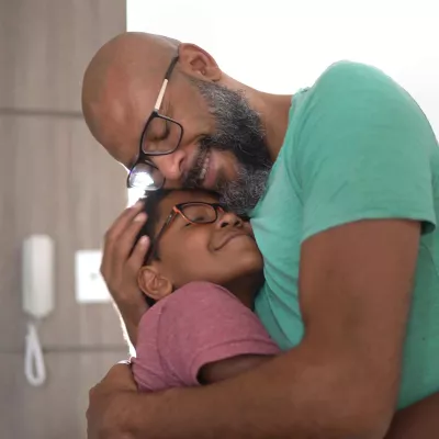 father embracing son at home