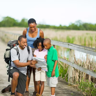 A family walking on a boardwalk together.