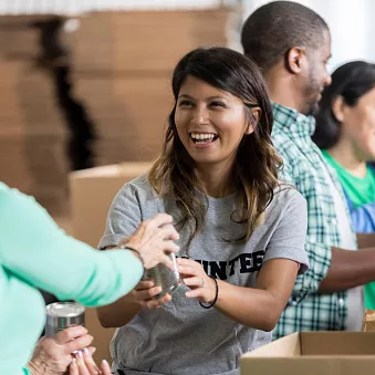 women giving woman glass while packing