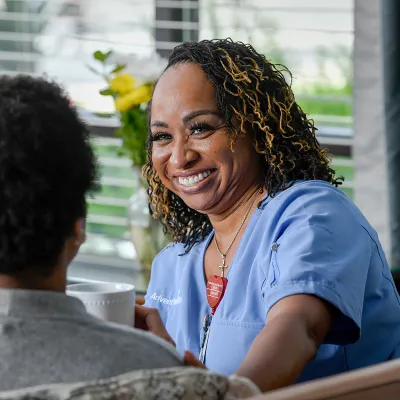 Black female nurse comforting black female patient.
