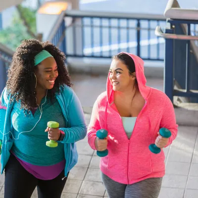 Two women exercising by running up some stairs