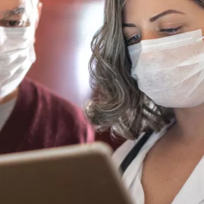 A doctor showing her patient something on her business tablet
