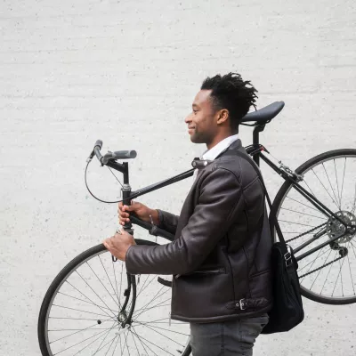 A man carries his bike after riding to work
