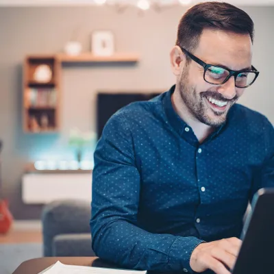 A man indoors and on his laptop