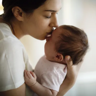 A mom kissing her infant.