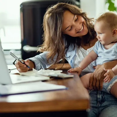 A mother and infant son at home in front of the computer. 